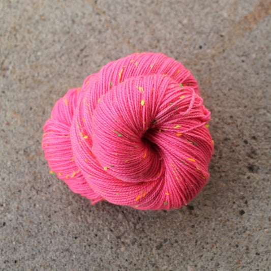 Pink skein of yarn on a concrete surface